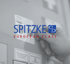 Spitzke European Class Logo vor einer Hand, die einen Prüfaufkleber anbringt.
