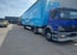 Blauer Mercedes-Benz LKW mit hellblauem Amazon Prime Anhänger parkt auf einem Logistikgelände.