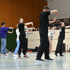Mehrere Personen in einem Fitnessstudio, die die Hände in Tanzpositionen halten.