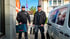 Zwei Handwerker in schwarzen Jacken mit Werkzeugkoffern stehen neben einem weißen Transporter.