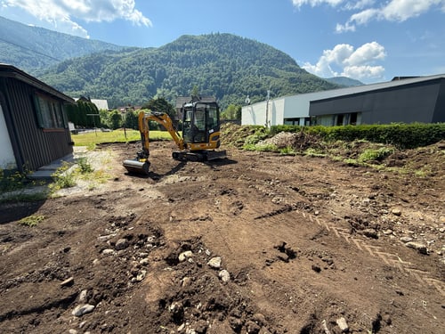 Bauplatz mit Bagger und freigelegtem Erdreich
