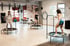 Drei Frauen trainieren auf Trampolinen in einem Fitnessstudio mit hohen Decken und weißen Wänden.