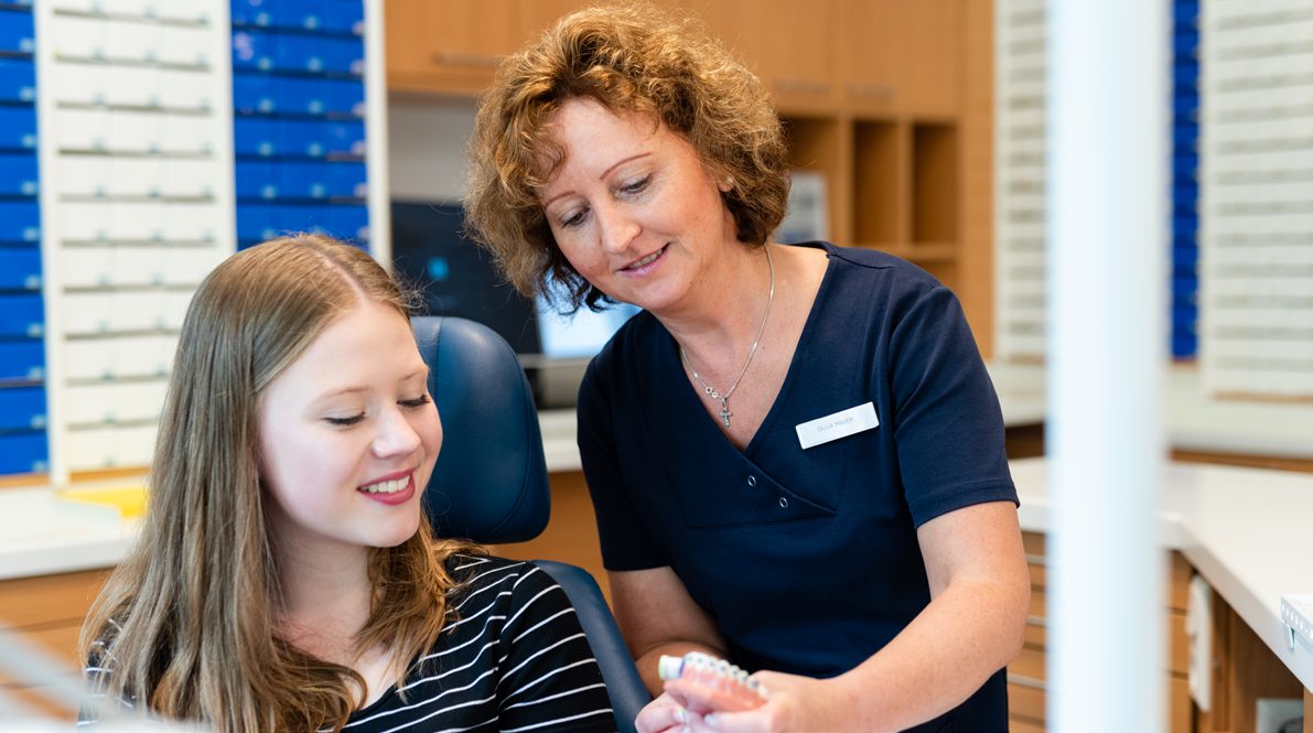Kieferorthopädin im Gespräch mit einer jungen Patientin