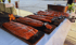 Fünf Lachsfilets auf Holzbrettern über offener Flamme grillend, mit Gitterspuren und grobem Salz.
