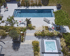 Ein großer Garten mit einem rechteckigen Pool, einer Terrasse und einem Whirlpool.