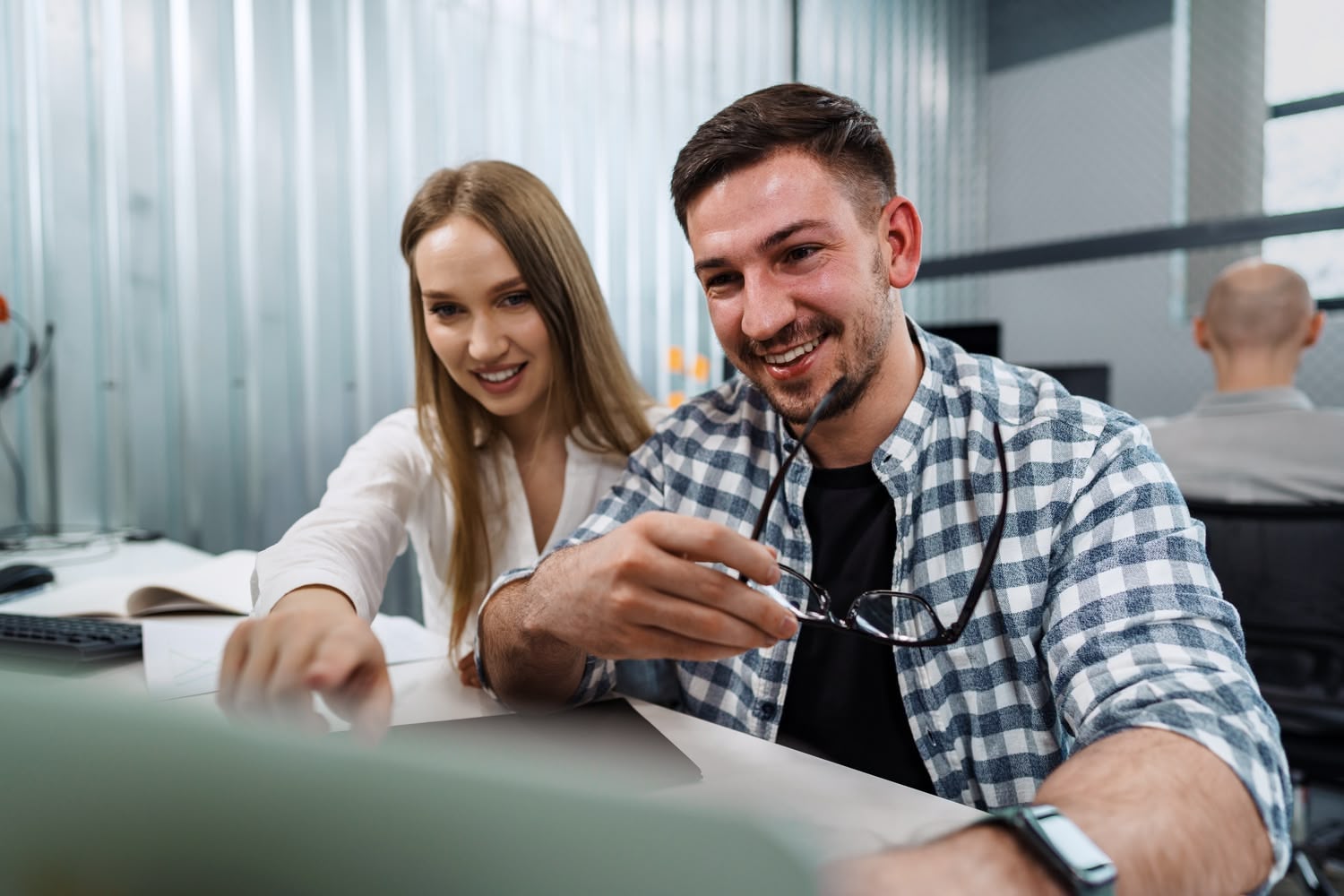 Servicemitarbeiter zeigt Kundin digitales Banking am Smartphone