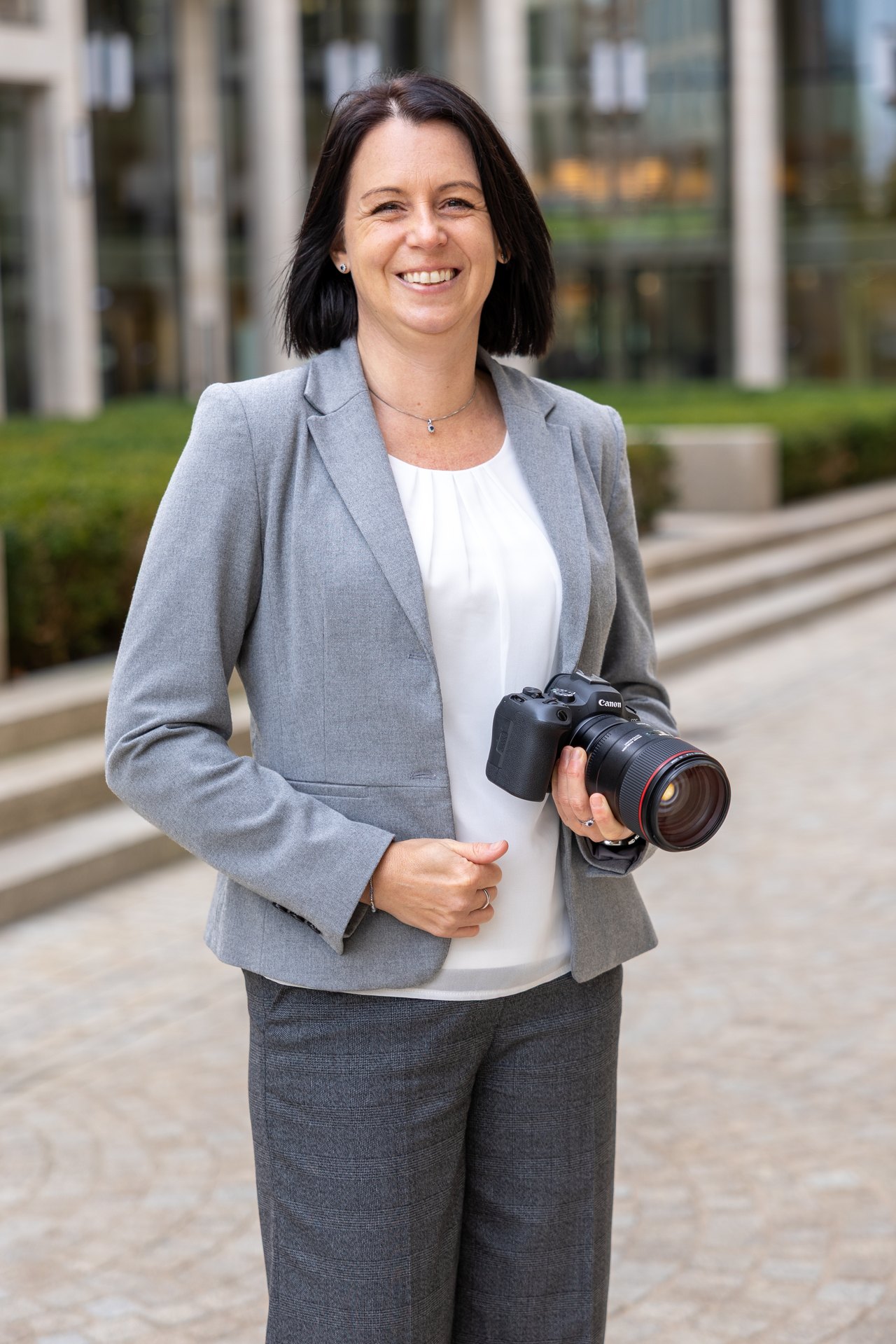 Fotografin Claudia Edhofer vor einem gläsernen Gebäude in Frankfurt a.M.