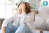 A distressed woman sitting on the floor, holding her head, experiencing pelvic floor concerns.