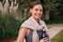 A young, happy woman in activewear holding a water bottle.
