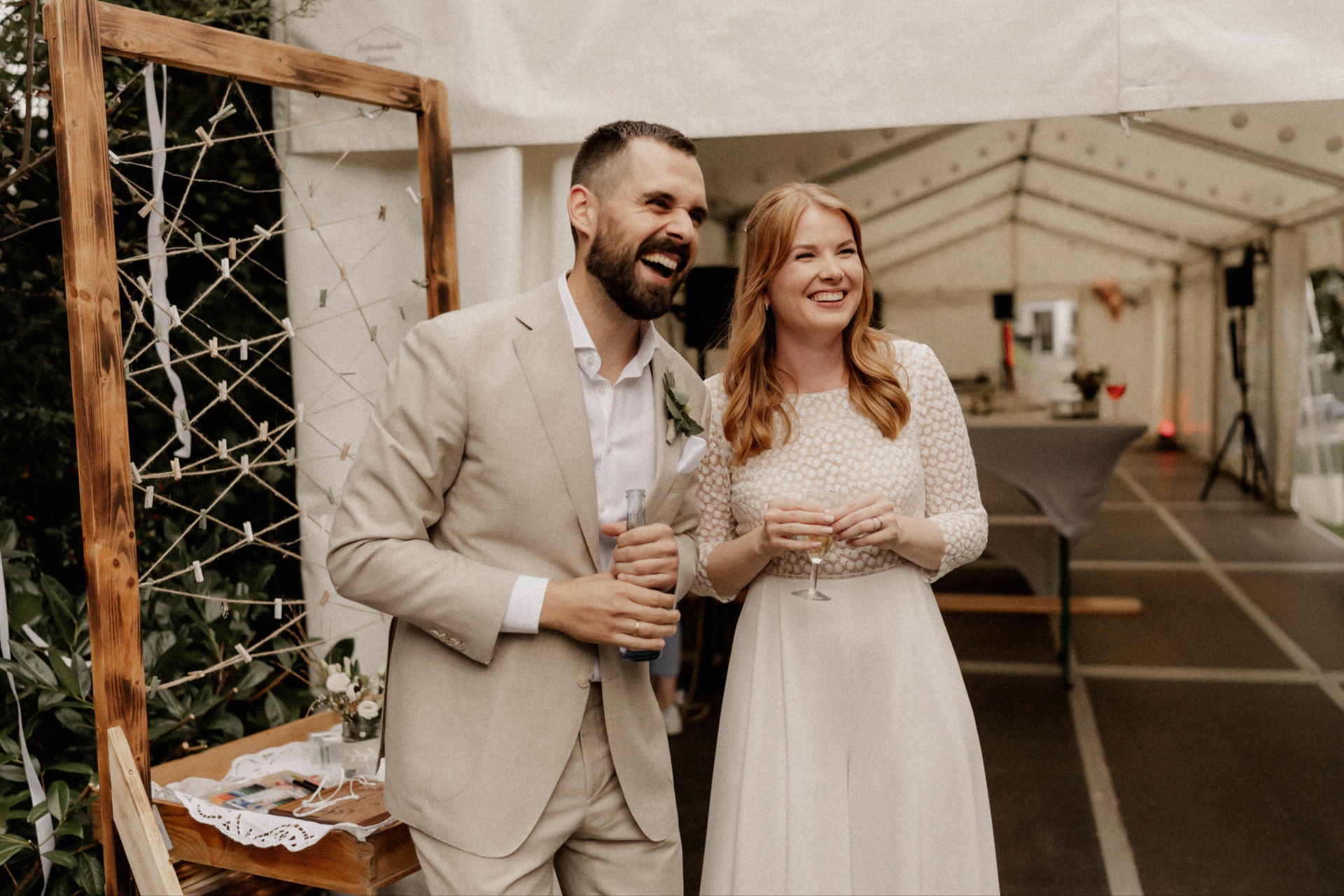 Brautpaar lacht gemeinsam beim Sektempfang nach der standesamtlichen Hochzeit in Kaarst.