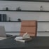 Geöffnetes Notizbuch auf einem Schreibtisch mit Laptop und Bürostuhl.