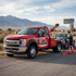 Towing Sandy roadside assistance service helping a stranded driver while preparing a vehicle for towing on the shoulder of a road.