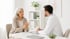 A female patient discusses nerve pain with a male doctor in a clinic.