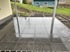 Neu verlegte, glänzende graue Terrassenplatten aus Naturstein unter einer Überdachung im Garten.