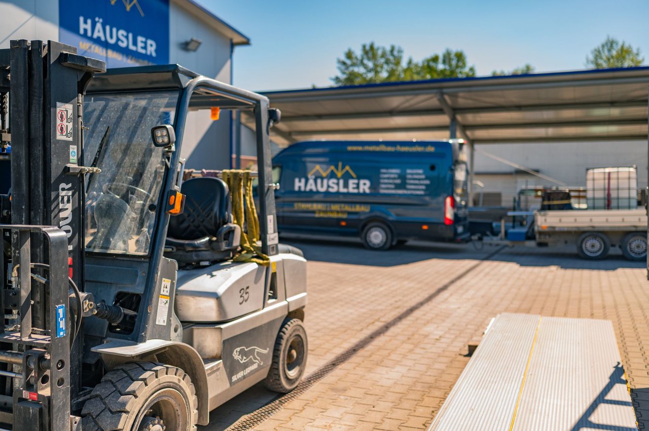 Stapler und Firmentransporter auf dem Hof von Häusler Metallbau
