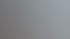 Ein junger Mann mit Brille und blauem Hemd sitzt vor einer grauen Wand neben einer Stehlampe und einer Zimmerpflanze.