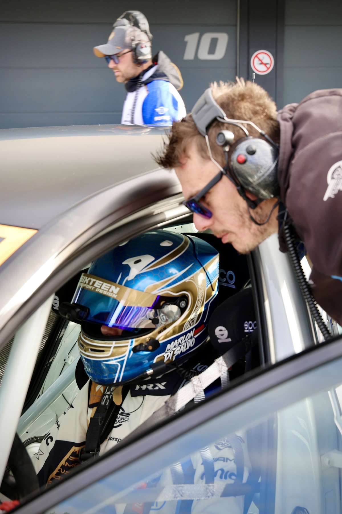 Ein Teammitglied beugt sich ins Cockpit zu Marlon