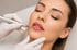 Eine Frau mit geschlossenen Augen erhält eine Lippenpigmentierung mit einem Permanent-Make-up-Gerät.
