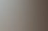 Lächelnde Frau in weißer Bluse sitzt am Schreibtisch mit zwei Monitoren in einem hellen Büro.