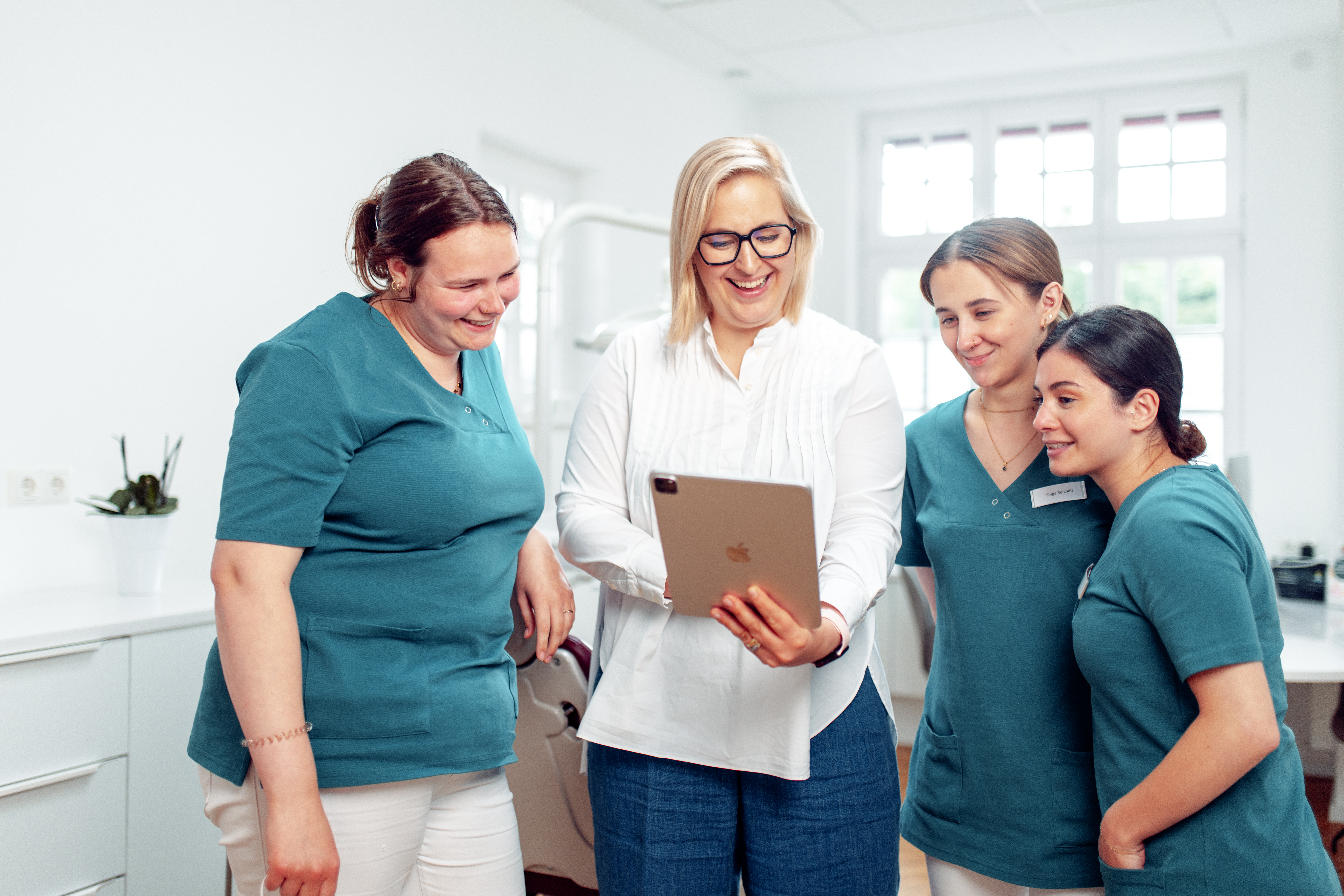 Julia Wenderhold arbeitet mit einem Praxisteam am Tablet