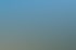 Stadtansicht von Aue im Erzgebirge mit bunten Häuserzeilen vor bewaldeten Hügeln unter blauem Himmel.