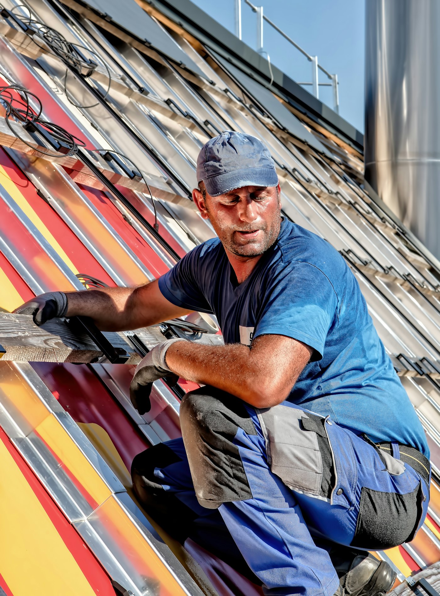 Roofer seated on a residential roof slope during a repair