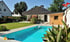 Moderner Garten mit rechteckigem Pool, Holzhaus und gepflegtem Rasen unter blauem Himmel.