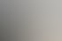 Eine lächelnde Frau mit blonden Haaren telefoniert am Schreibtisch.