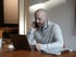 CEO Benjamin Schwarz telefoniert konzentriert mit Smartphone am Ohr vor Laptop.