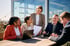 Das komplette BRIDGE Industry Consulting Team sitzt an einem Tisch in einer Besprechung.  