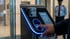 Ein Finger drückt auf einen blauen, beleuchteten Fingerabdruckscanner an einem schwarzen Authentifizierungsgerät.