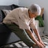 Elderly woman gently stretching to ease arthritis discomfort