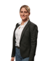 Eine junge Frau mit blonden Haaren, schwarzem Blazer, weißem Hemd und Jeans lächelt.