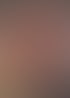 Eine Hand hält eine Strähne leuchtend rot gefärbter Haare einer Person, die auf einem Stuhl sitzt.