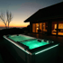 Beleuchteter grüner Whirlpool auf einer Holzterrasse vor einem Haus bei Sonnenuntergang.