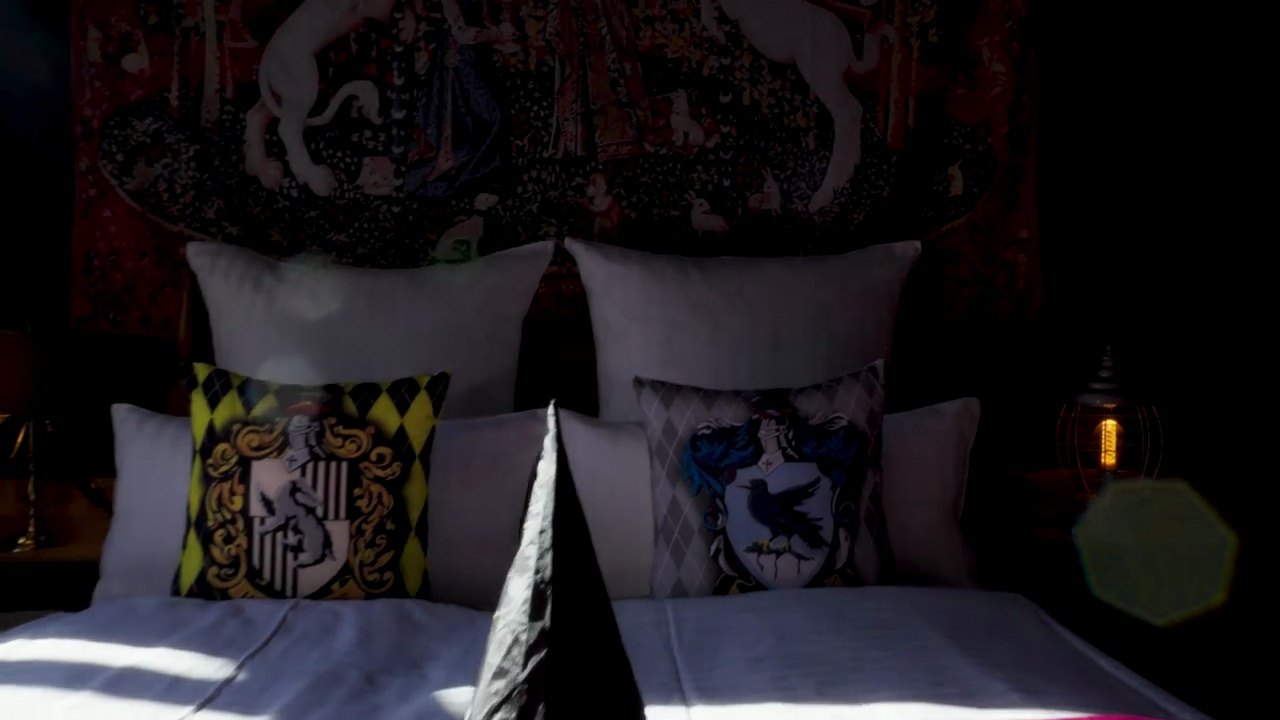 Schlafzimmer im Harry-Potter-Apartment in Hamburg mit Hogwarts-Wappen auf den Kissen - früher eine Gewerbefläche