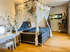 Ein Bettzimmer von dem Retreat Location, die von Thai Yoga Massage organisiert wird. Liebevoll eingerichtetes Schlafzimmer mit einem Himmelbett aus Holz und leichten Vorhängen, umgeben von Pflanzen und Naturmaterialien – ein Rückzugsort für tiefen Schlaf und Geborgenheit.