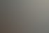 Drei brennende weiße Stumpenkerzen vor einem unscharfen Hintergrund mit warmen Lichtpunkten.