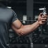 A man holding cjc-1295 bottle in a gym.