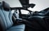 Innenansicht eines modernen Elektroautos mit blauen Ledersitzen, Panoramadach und Armaturenbrett mit Bildschirm.