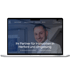 Ein Laptop zeigt die Webseite von Ahriman Immobilien mit einem lächelnden Mann und dem Text "Ihr Partner für Immobilien".