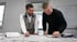 Christian und Fabian Roßmann arbeiten konzentriert an Bauplänen für Kundenprojekte.