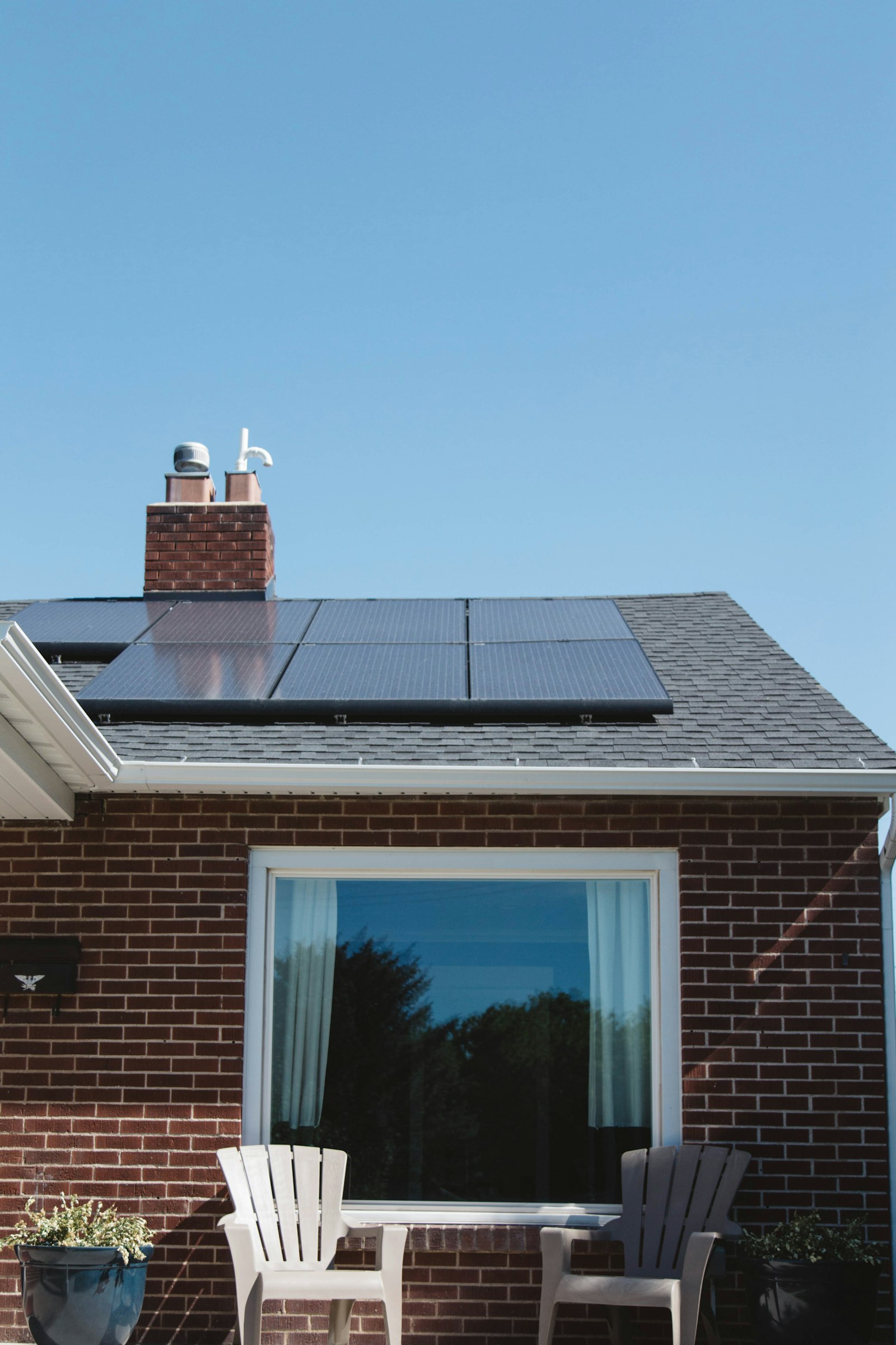 Brick house with solar panels on its roof, the kind of Frisco, TX home where owners weigh whether to replace the roof before solar