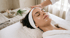 Frau mit Stirnband erhält eine entspannende Gesichtsbehandlung in einem Spa.