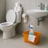 Sauberes Badezimmer mit Toilette, Waschbecken und einem orangefarbenen Eimer mit Reinigungsflasche und Tuch.
