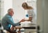 Nurse checks an older man's blood sugar as part of type 2 diabetes treatment.