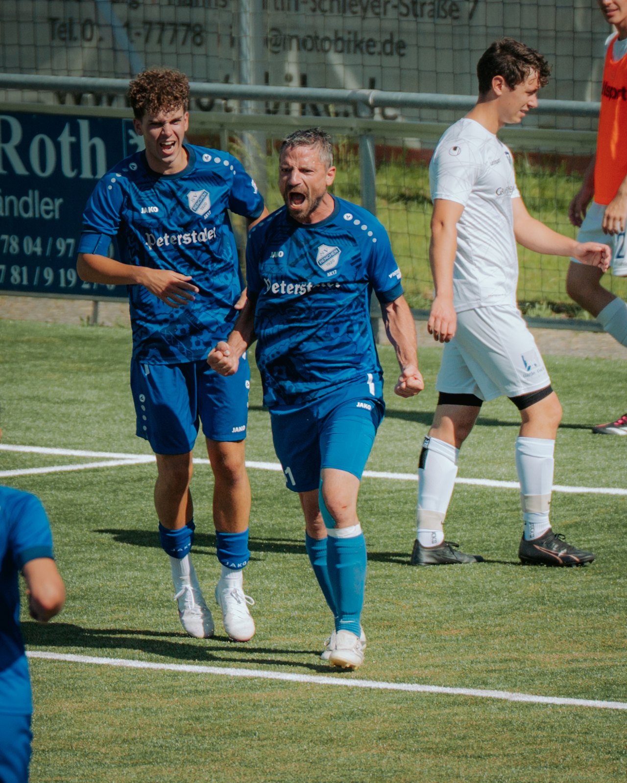Zwei Spieler in Blau jubeln nach dem Treffer
