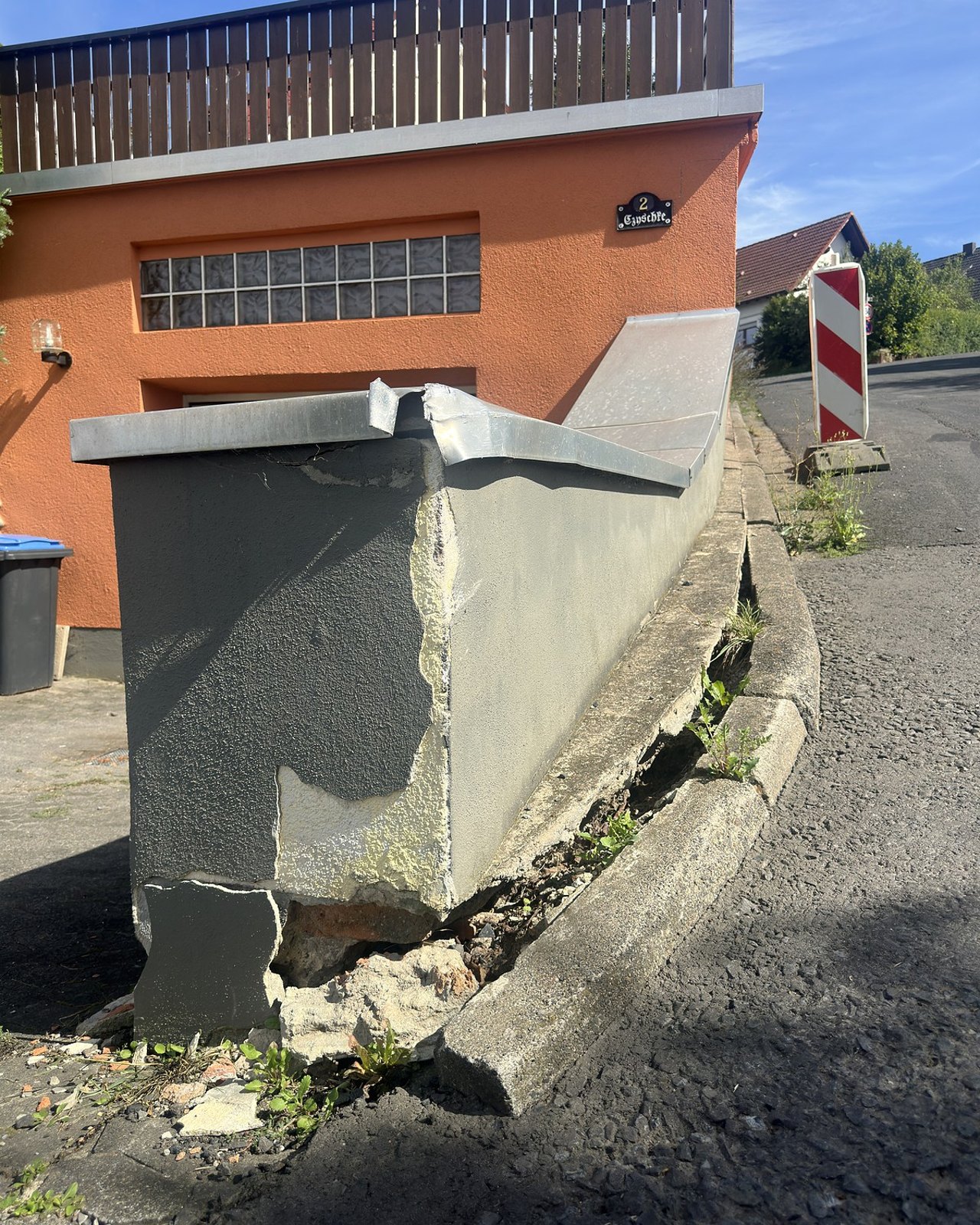 Gesamtansicht eines beschädigten Mauerbauteils mit sichtbar ausgebrochenem Putz und Mauerwerk.