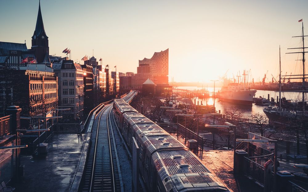 Blick über Gleise auf Hafen und Elbphilharmonie in Hamburg bei Sonnenuntergang