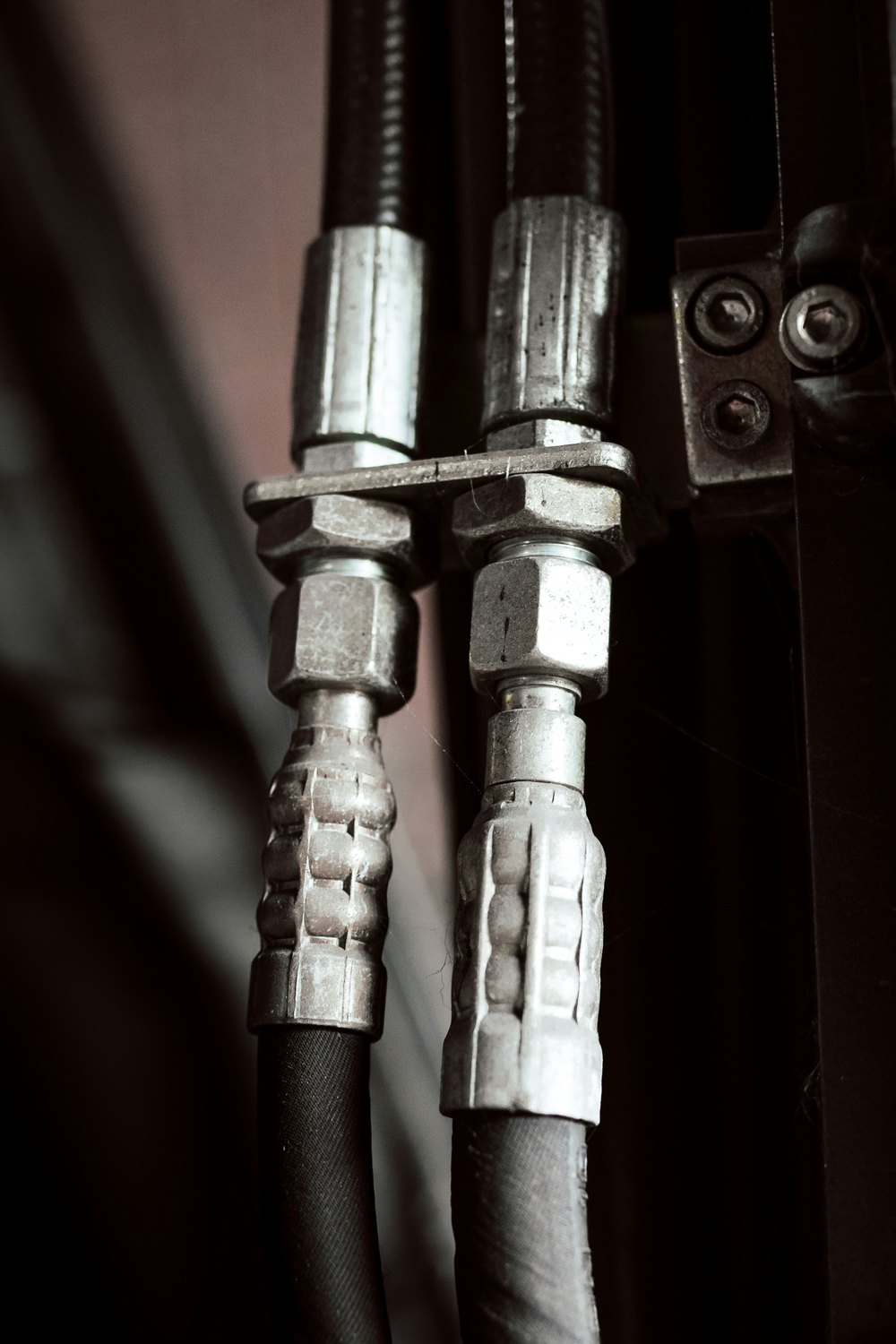 Nahaufnahme von Hydraulikschläuchen mit Pressarmaturen und Verschraubungen